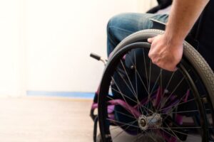 A person in a wheelchair after suffering a permanent disability from a spinal injury